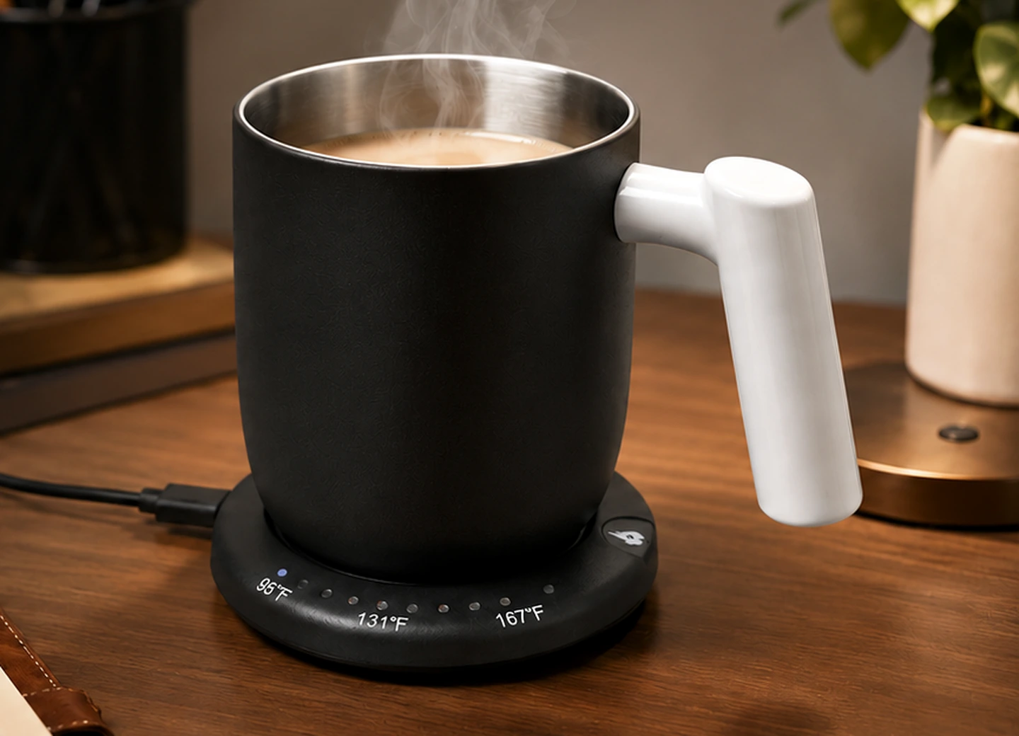 Schwarzer GREATIC GT-2 16oz beheizter Becher mit weißem Griff auf seiner angeschlossenen Schreibtischbasis mit sichtbarem Netzkabel